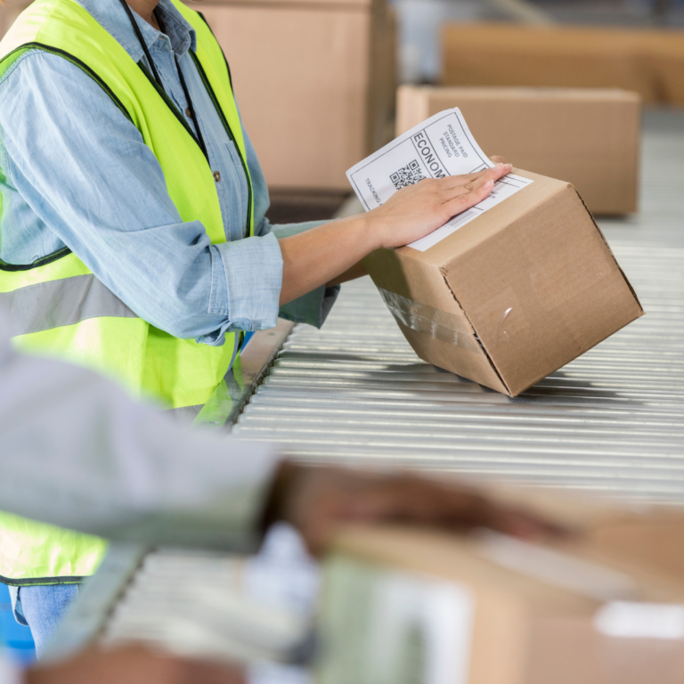 distribution center with employee placing a label on a box