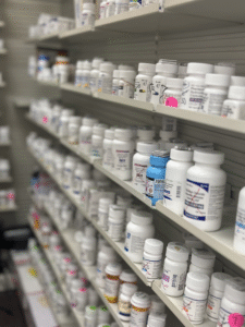 A shelf with white prescription bottles in the pharmacy